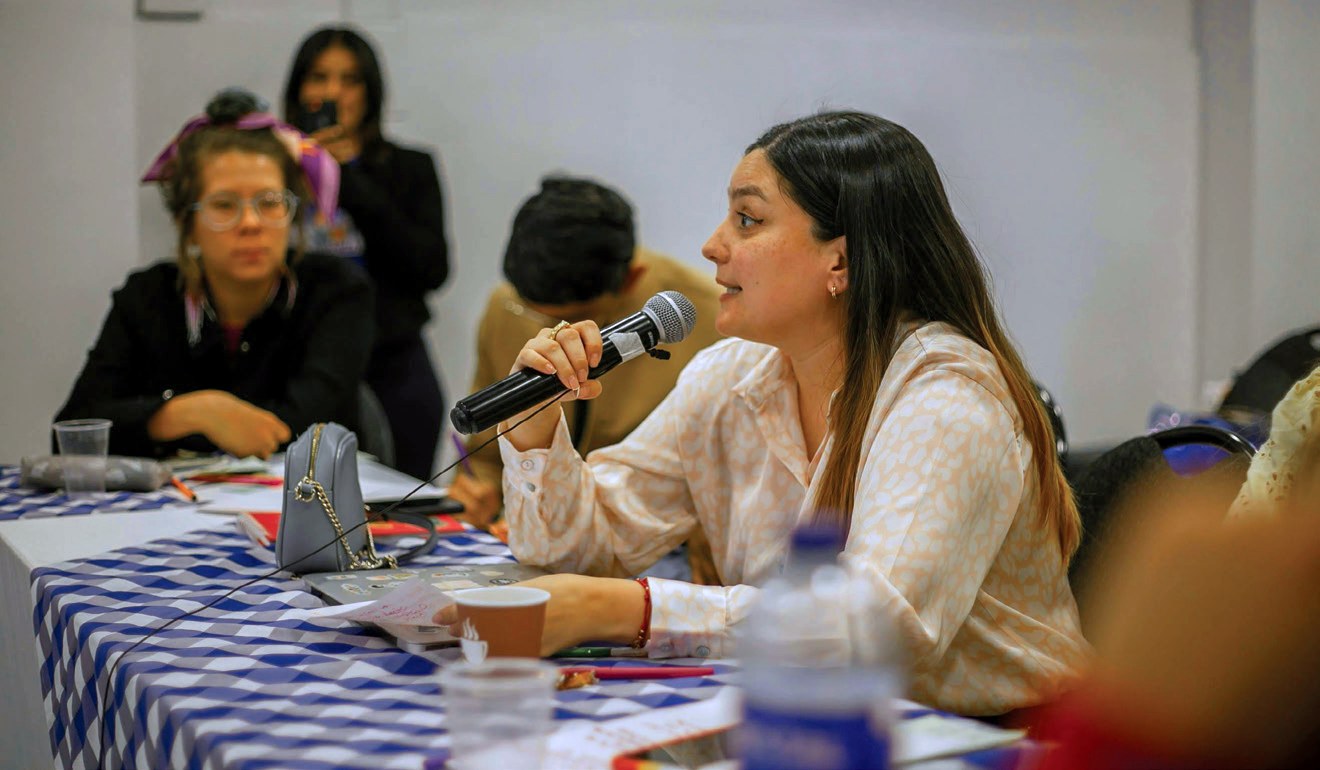 A young delegate speaks into a microphone during a youth policy convening
