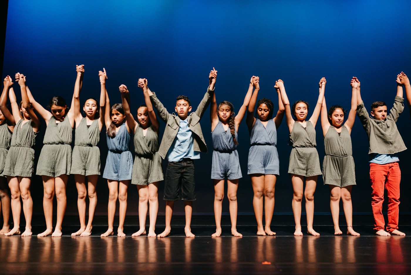 A Step Beyond dancers joining hands onstage at a performance